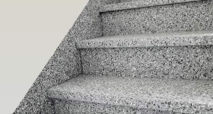 A close up of a set of stairs with a white wall.