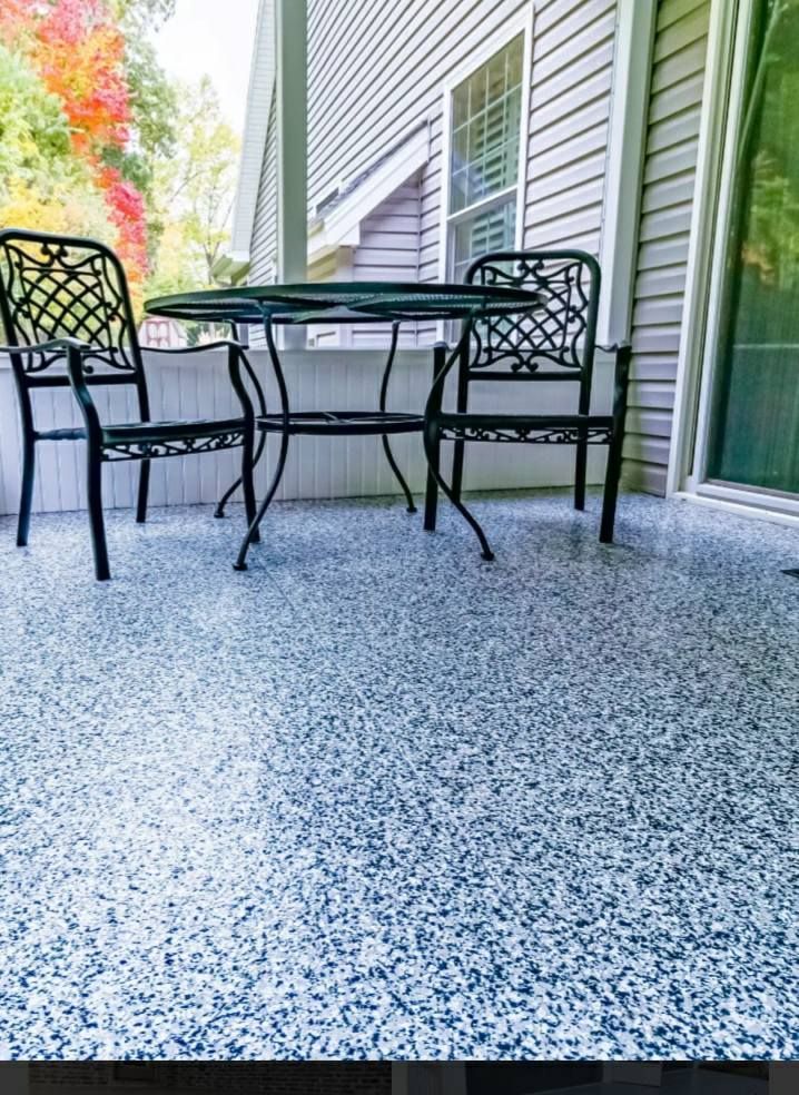 There is a table and chairs on the porch of a house.