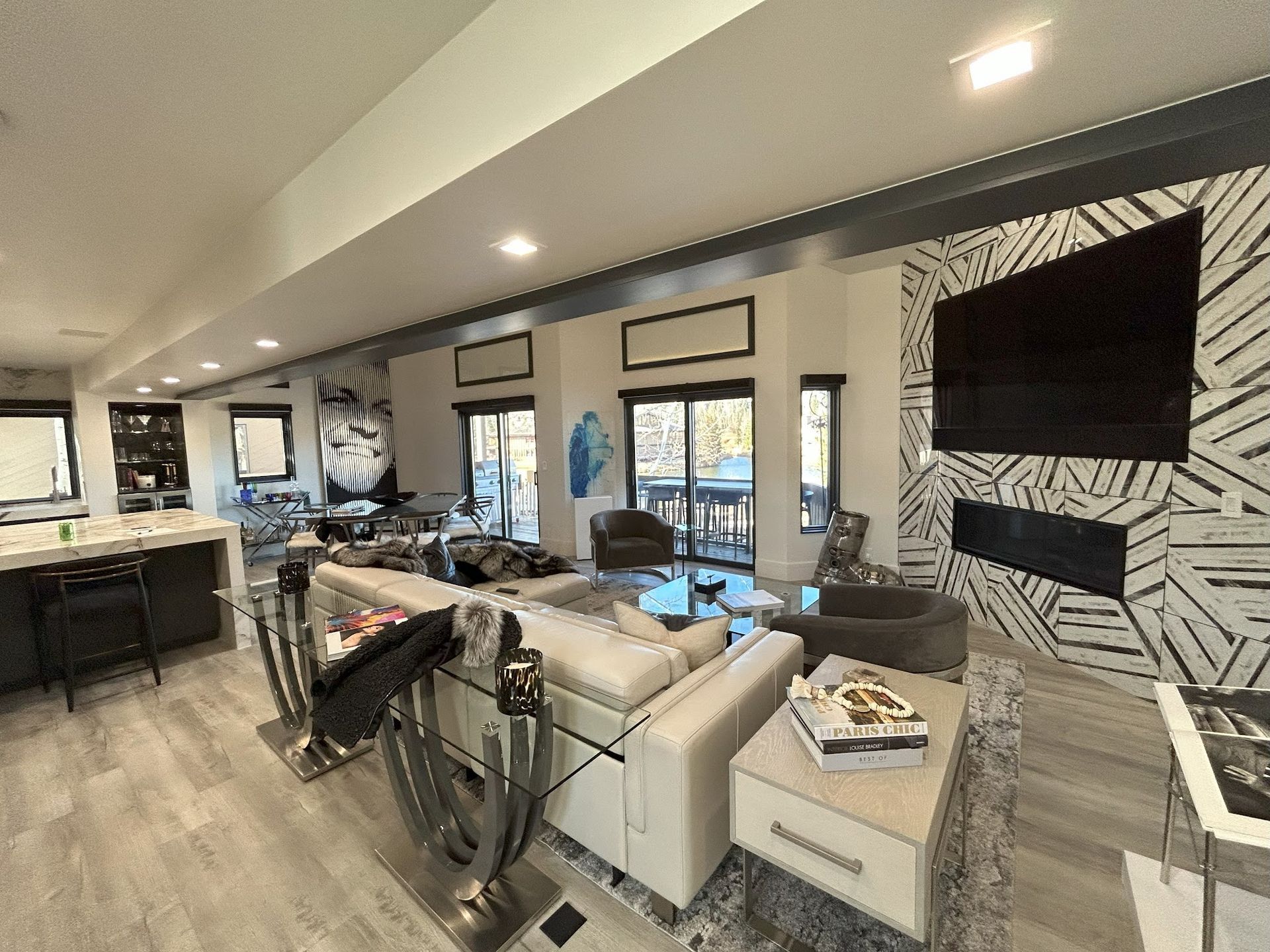 A living room with a couch , chairs , a television and a fireplace.