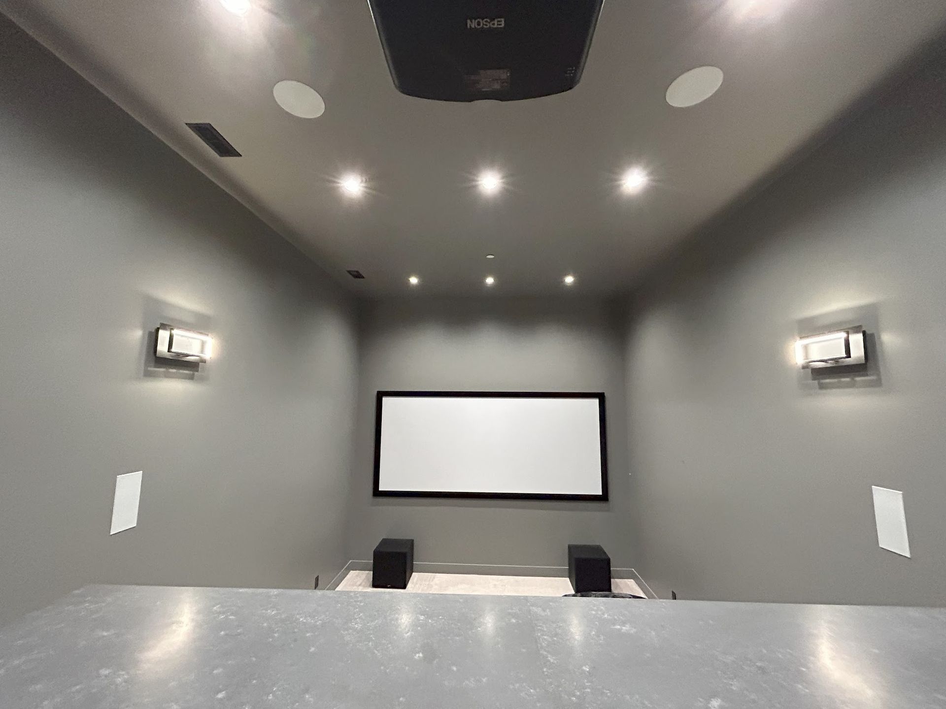 A home theater with a projector and a large screen.