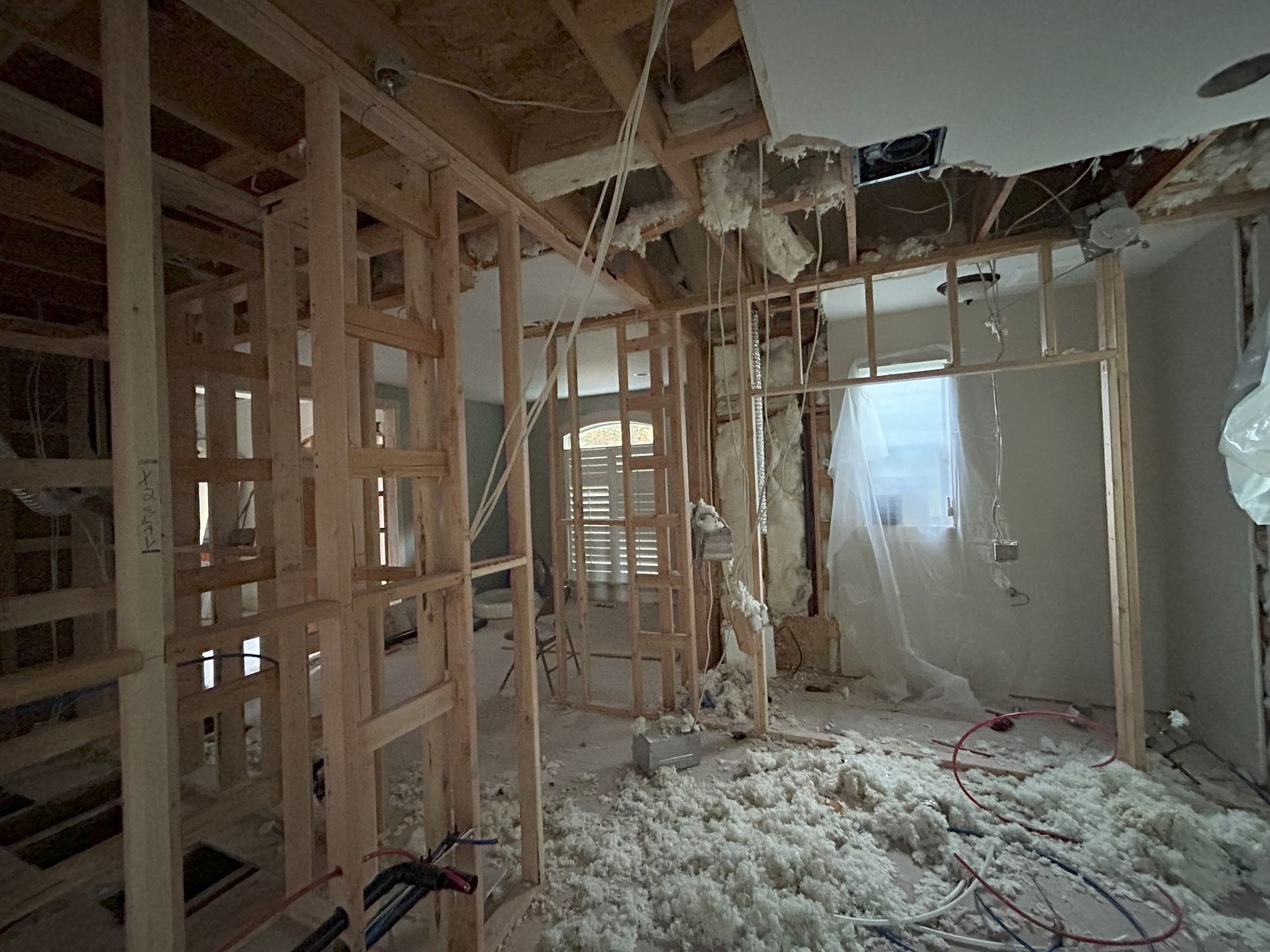 A room in a house under construction with a hole in the ceiling.