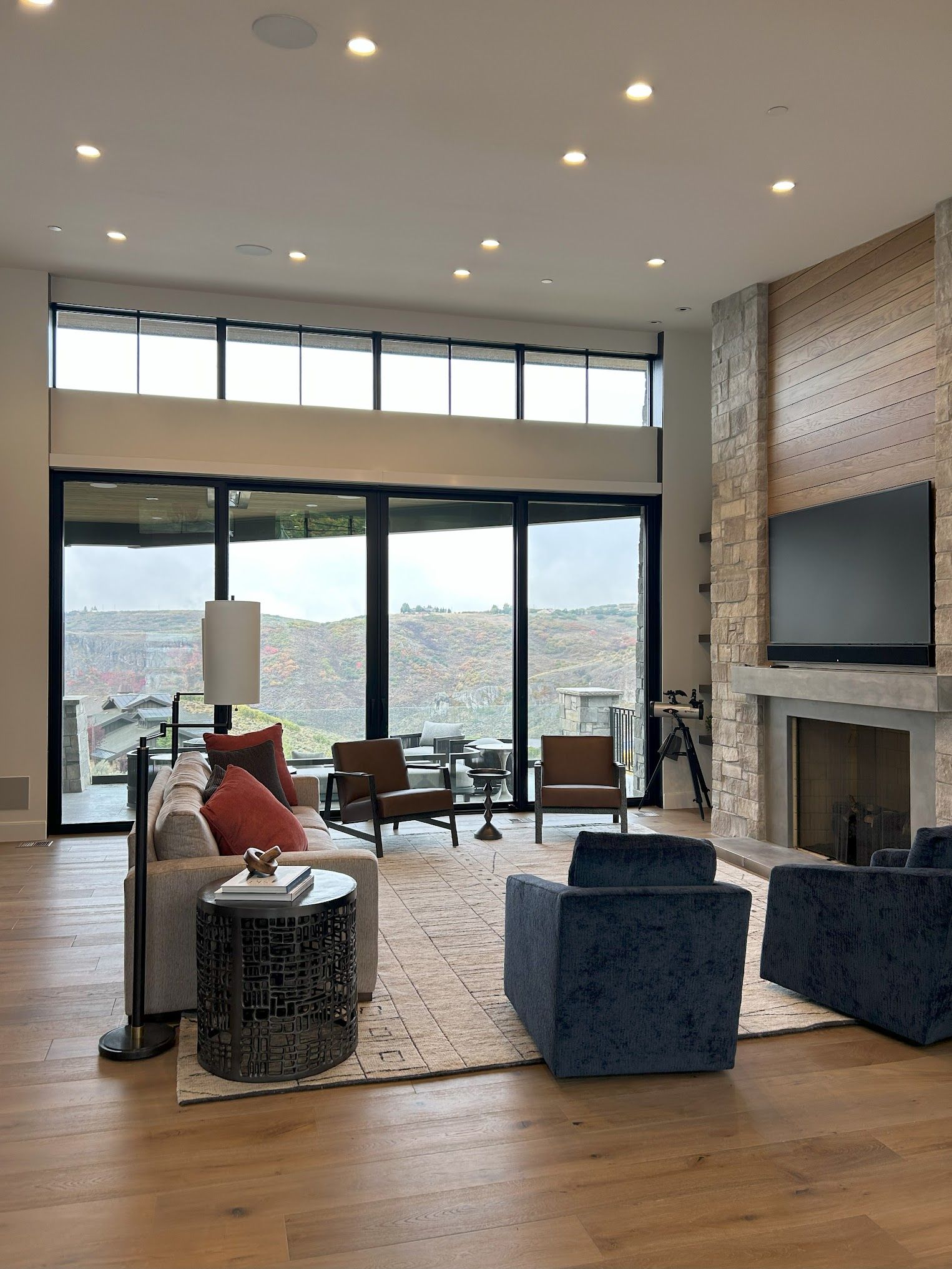 A living room with a couch , chairs , television and fireplace