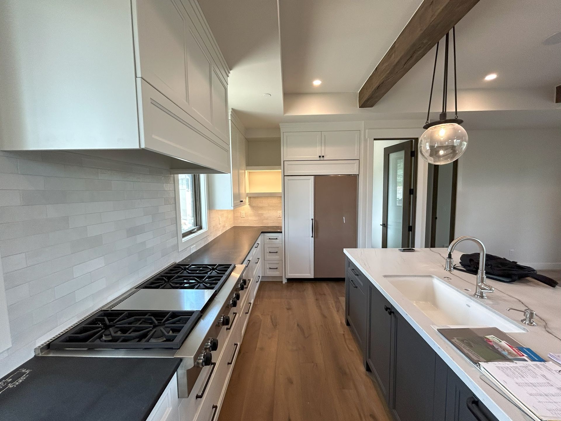 A kitchen with a stove top oven , sink , and refrigerator.