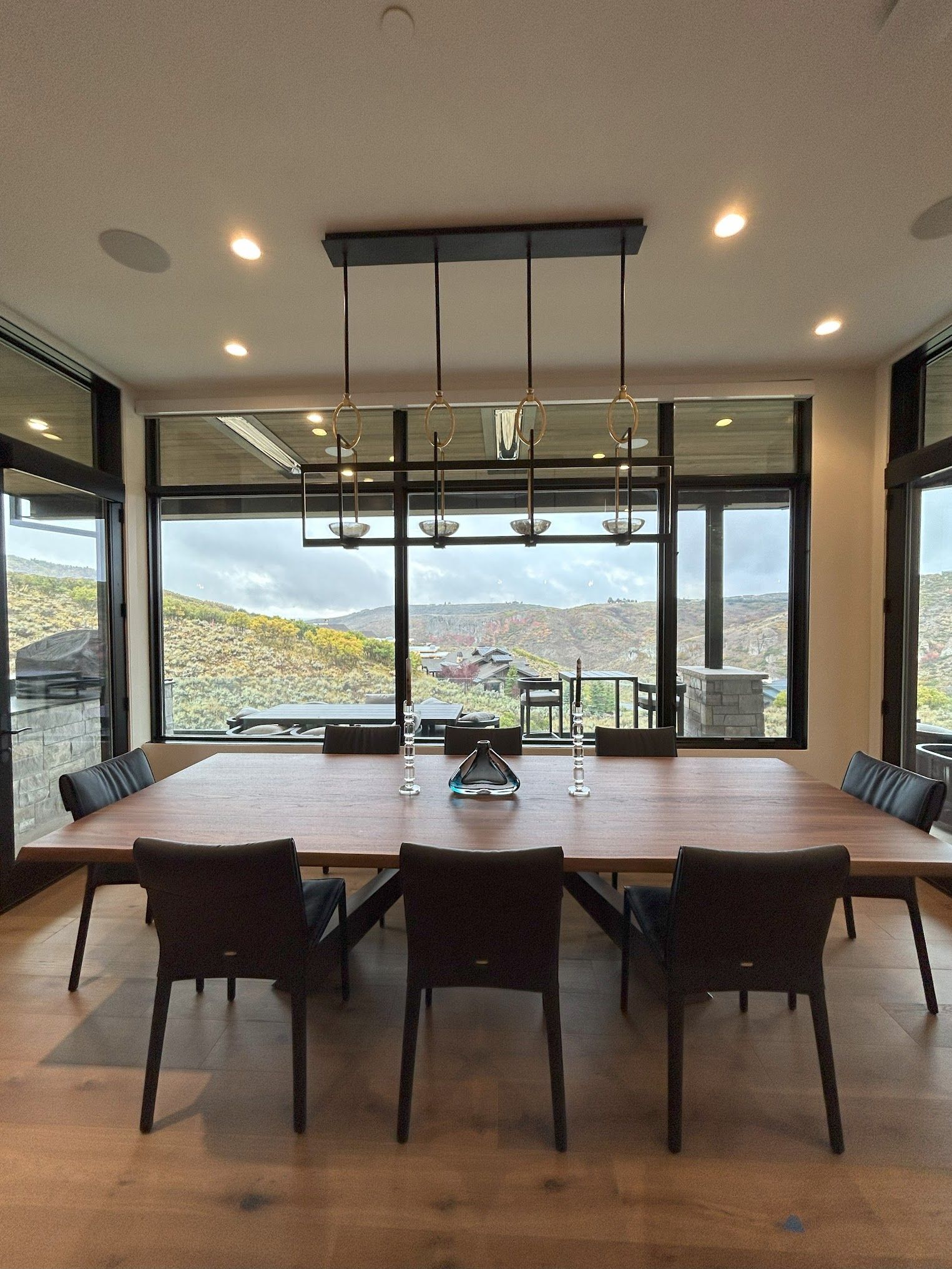A dining room with a large wooden table and chairs