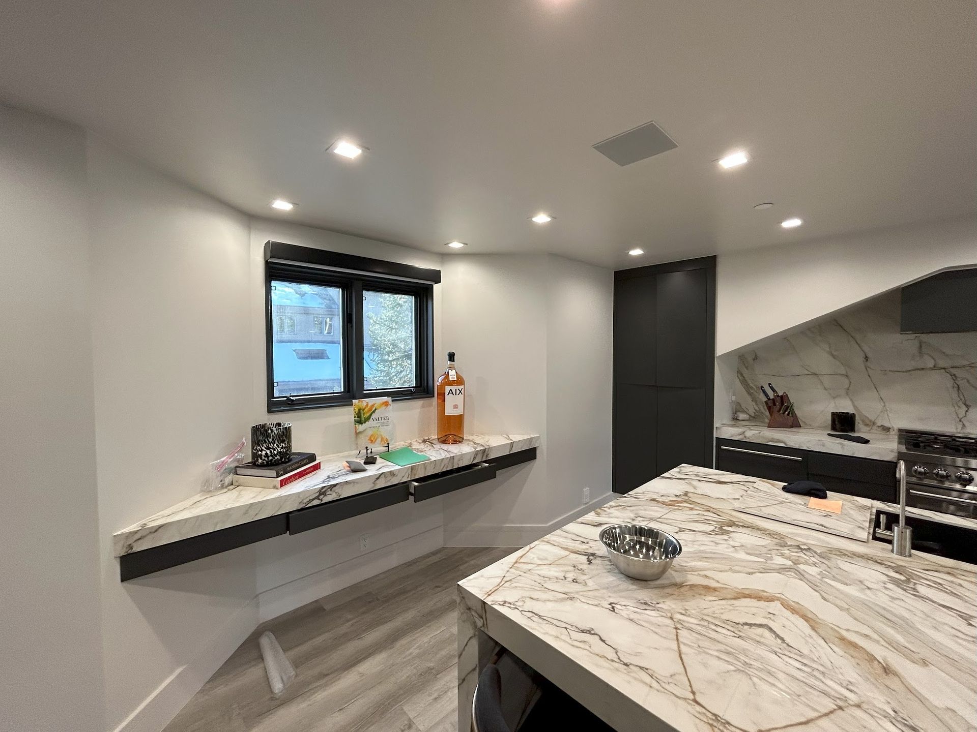 A kitchen with a large island and a marble counter top.