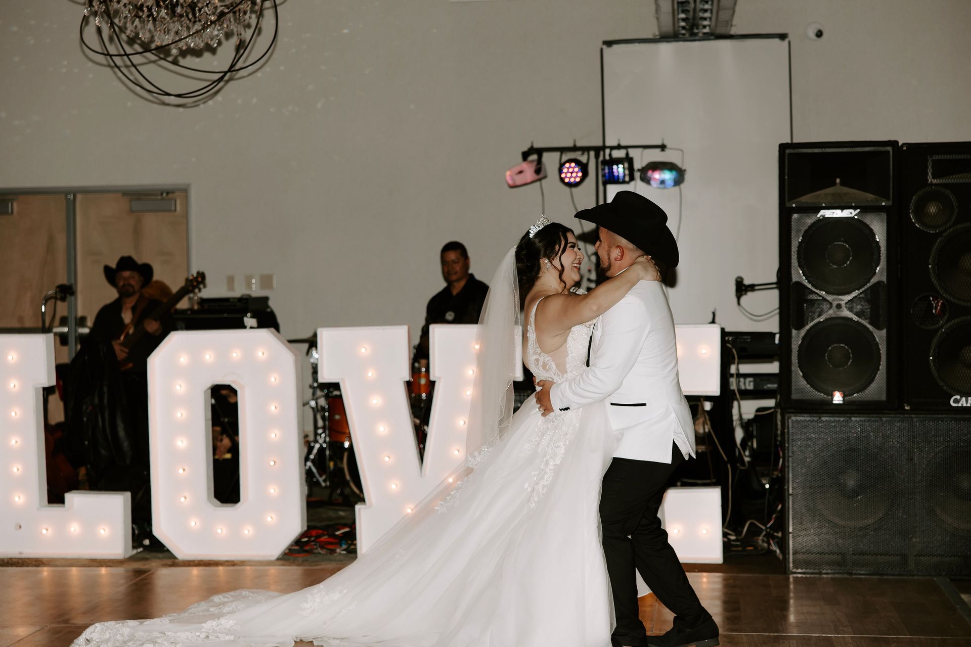 A bride and groom dance in front of a love sign – Pasco, WA - Decoraciones Garcia