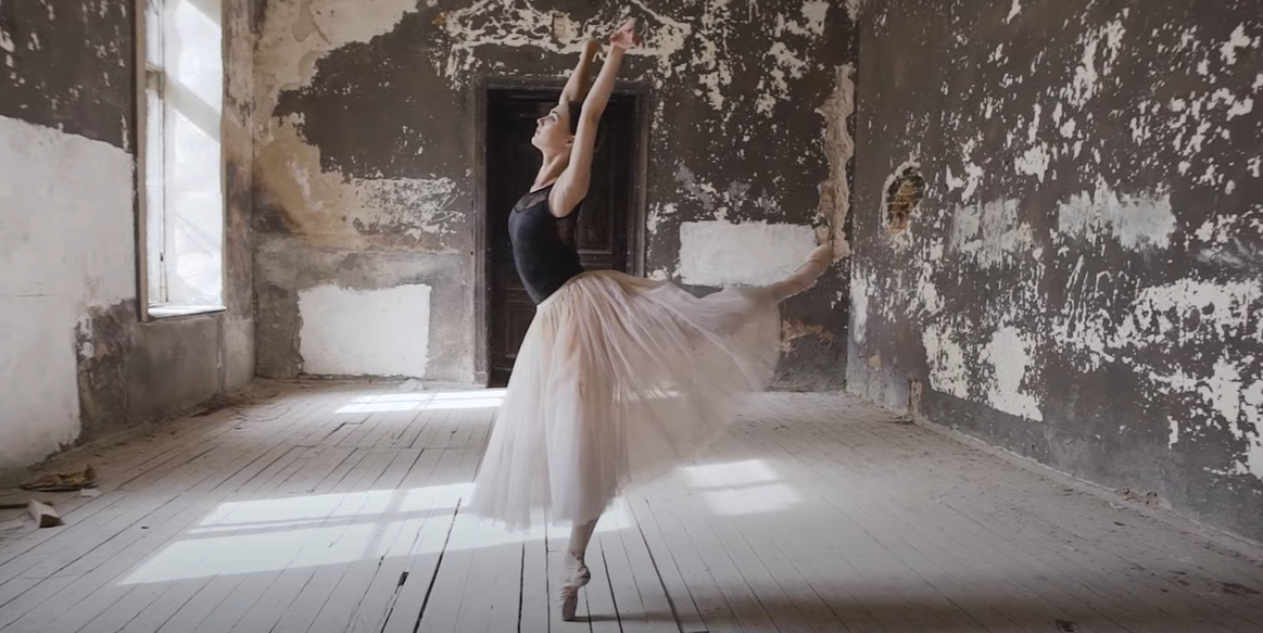 A ballerina is dancing in an empty room.