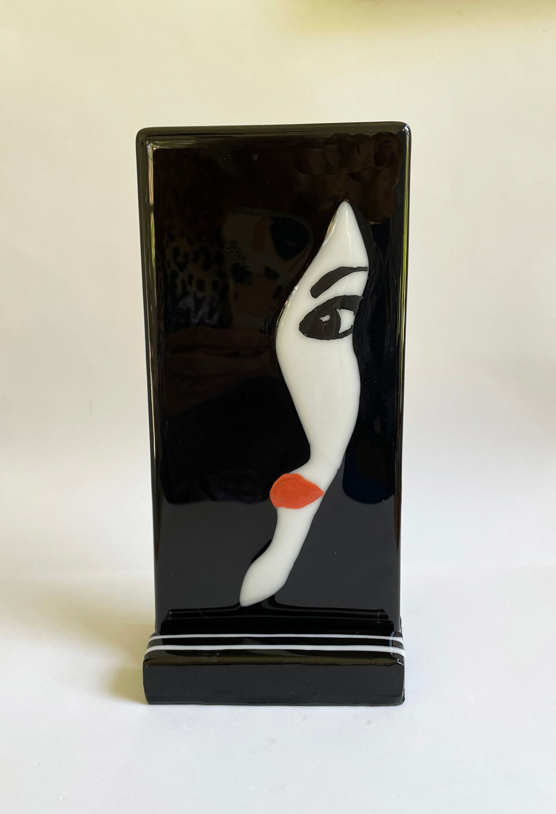 A black panel on glass stand with a woman's face 