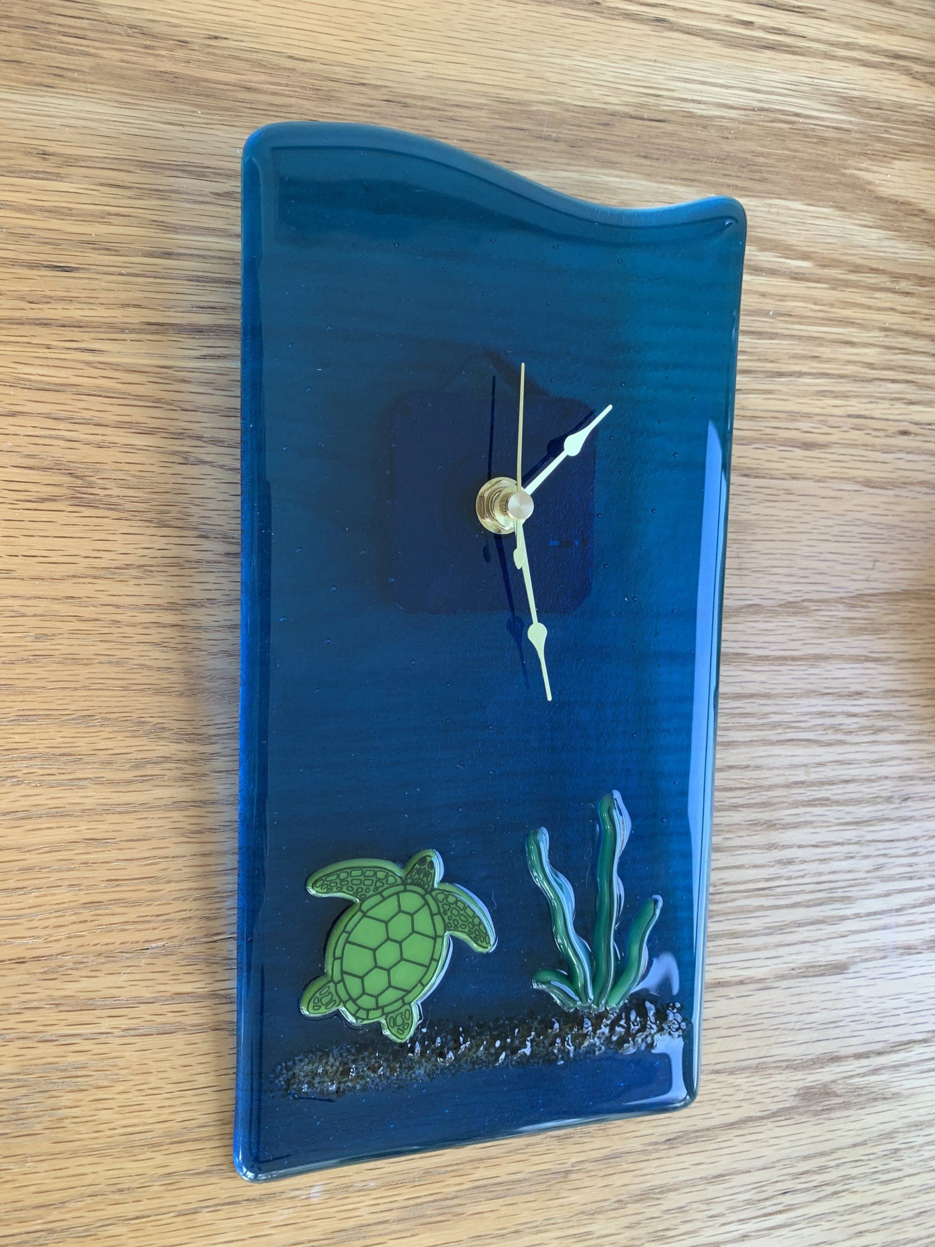 Wall clock with swimming turtle and see grass