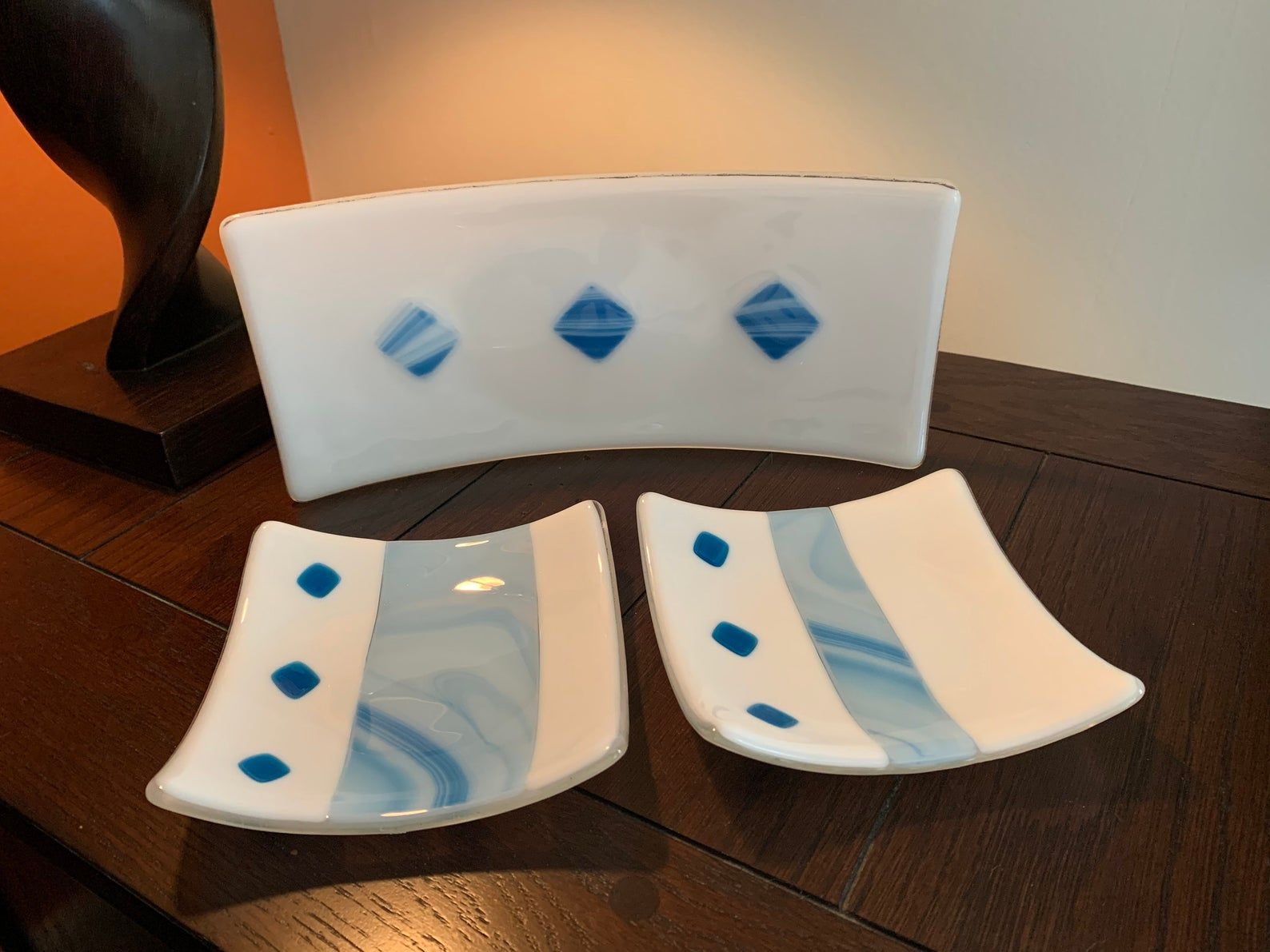 two white plates with blue diamonds on them sit on a table