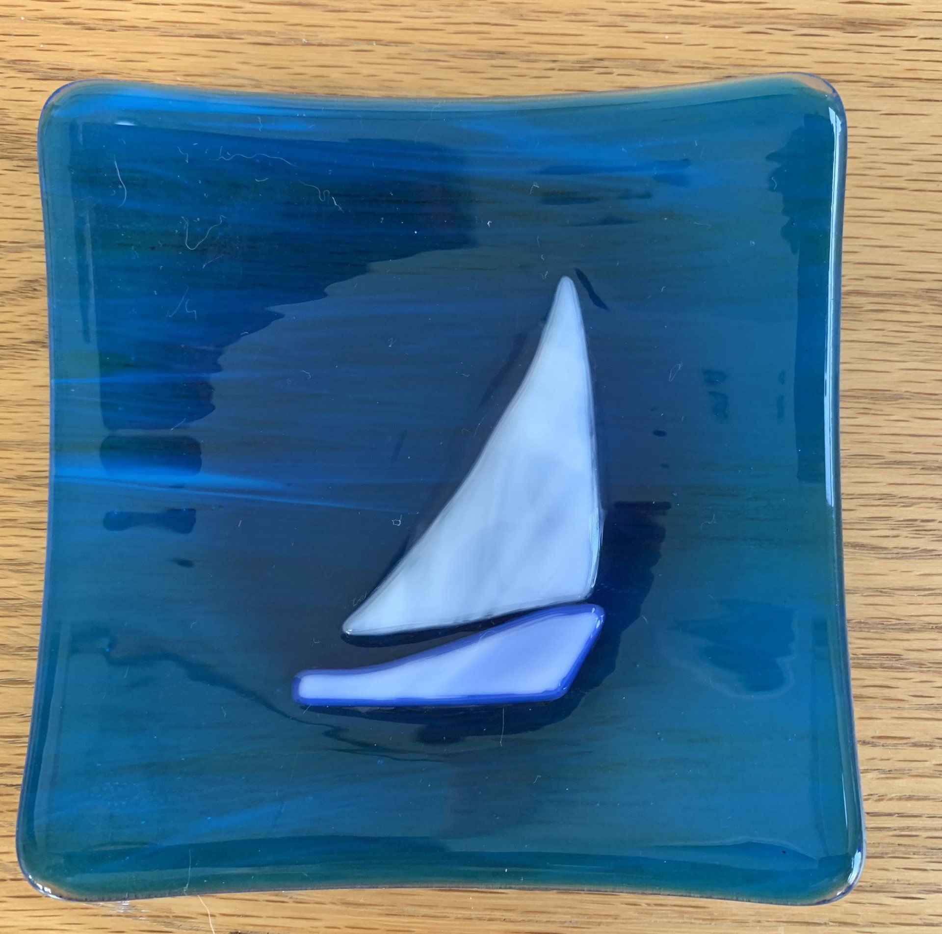 small blue plate with sailboat in center