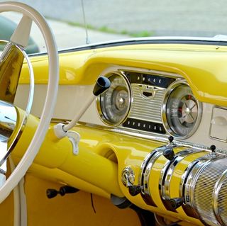 A yellow car with a steering wheel and dashboard