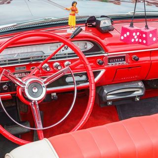 A red car with a steering wheel that says ' ford ' on it