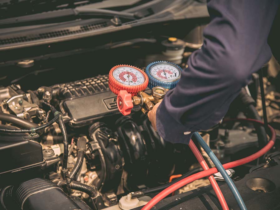 A man is working on the engine of a car.