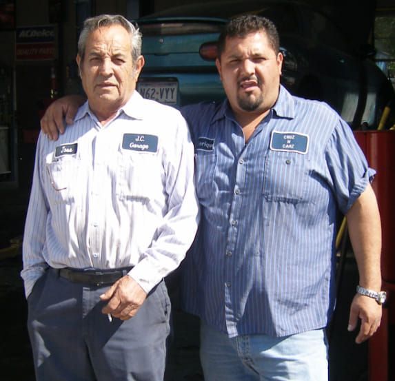 Two men standing next to each other with one wearing a name tag that says jc