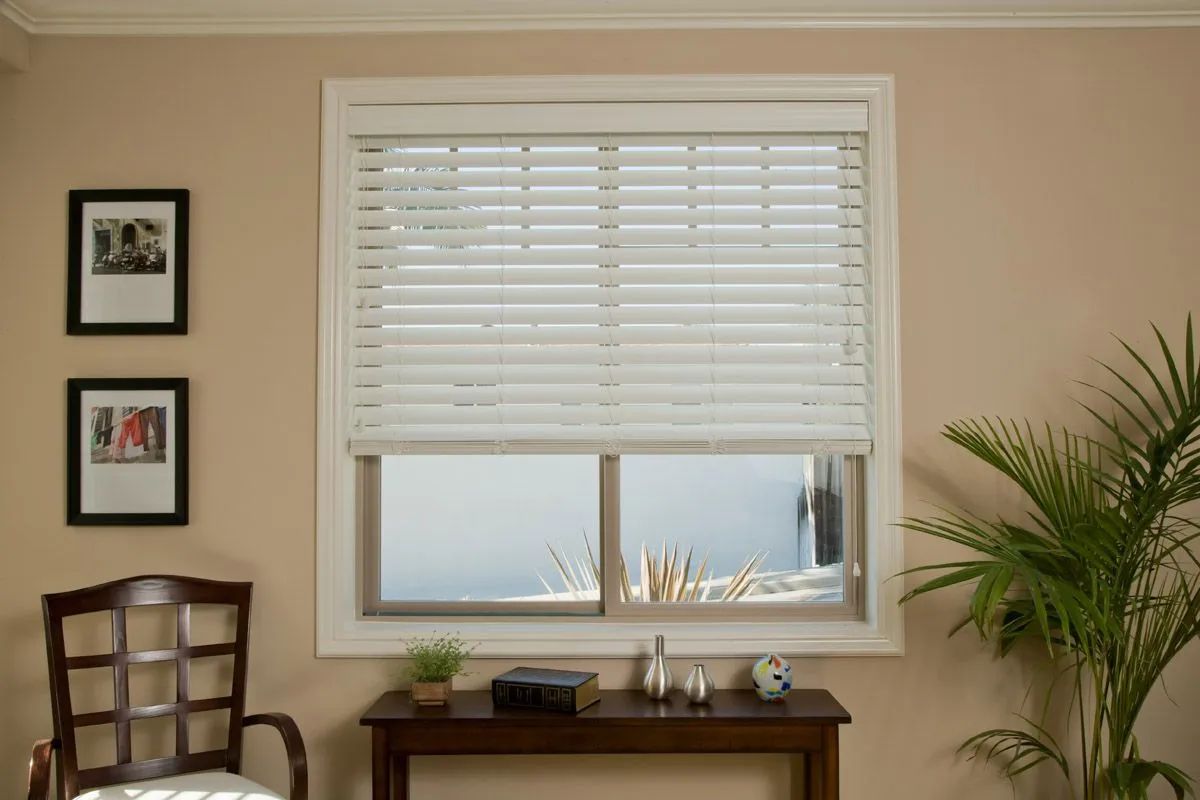Two windows with gray horizontal pleated shades; one is fully closed and the other is partially raised.