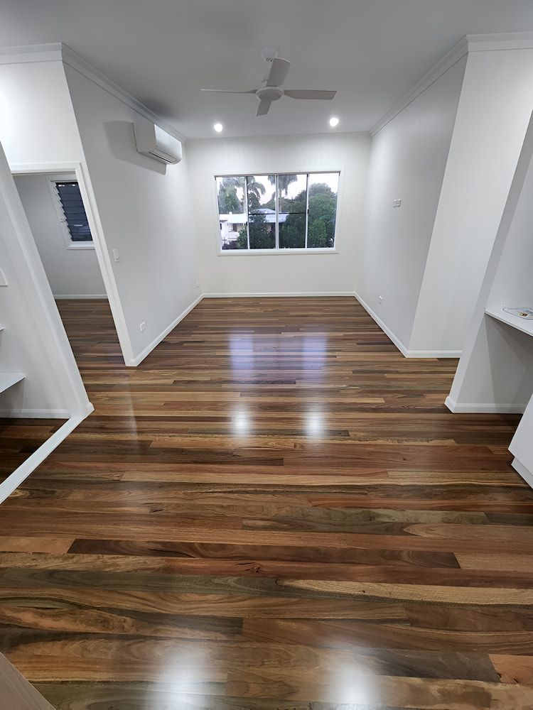 A Living Room With Hardwood Floors and a Ceiling Fan — ATM Floors In Mount Louisa, QLD