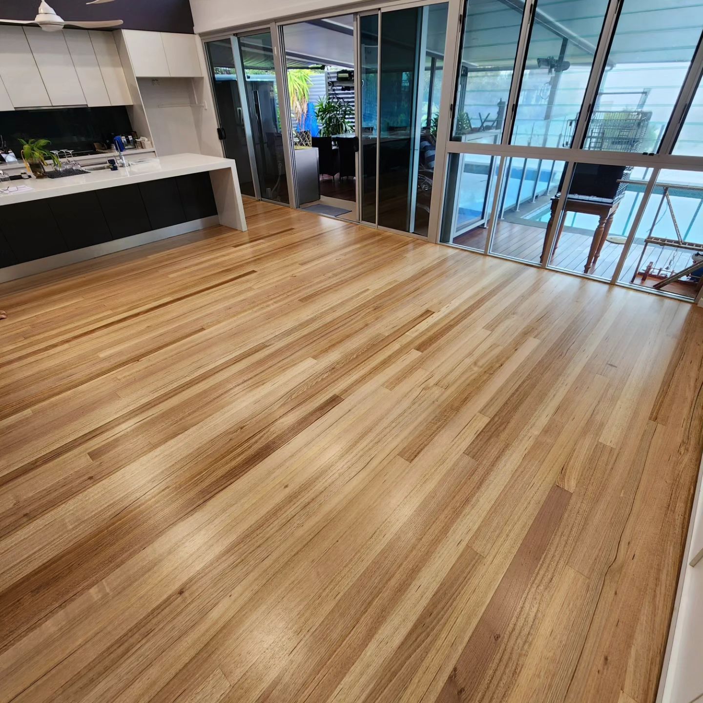 A Set of Wooden Stairs With a Black Railing in a Building — ATM Floors In Mount Louisa, QLD