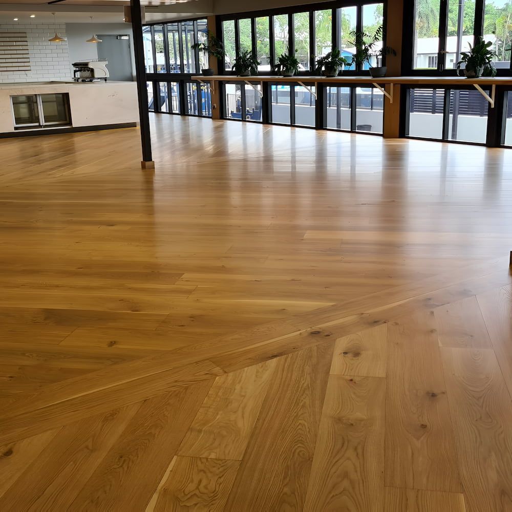 A Large Room With Hardwood Floors and Purple Walls — ATM Floors In Mount Louisa, QLD