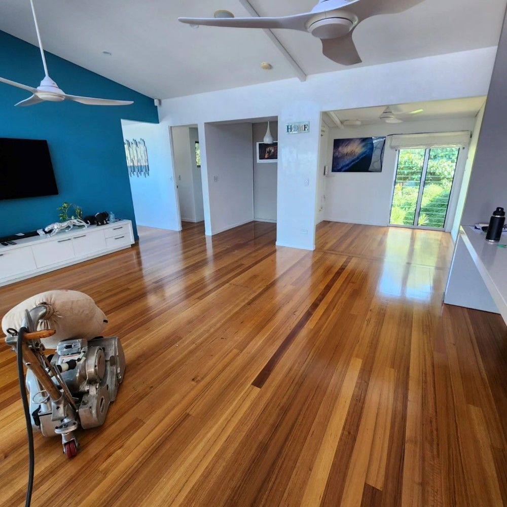 A Wooden Floor is Being Sanded in a Living Room — ATM Floors In Mount Louisa, QLD