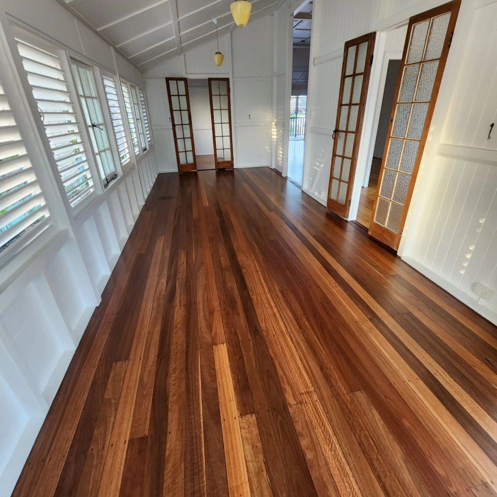 A Long Hallway With Hardwood Floors and White Shutters — ATM Floors In Mount Louisa, QLD