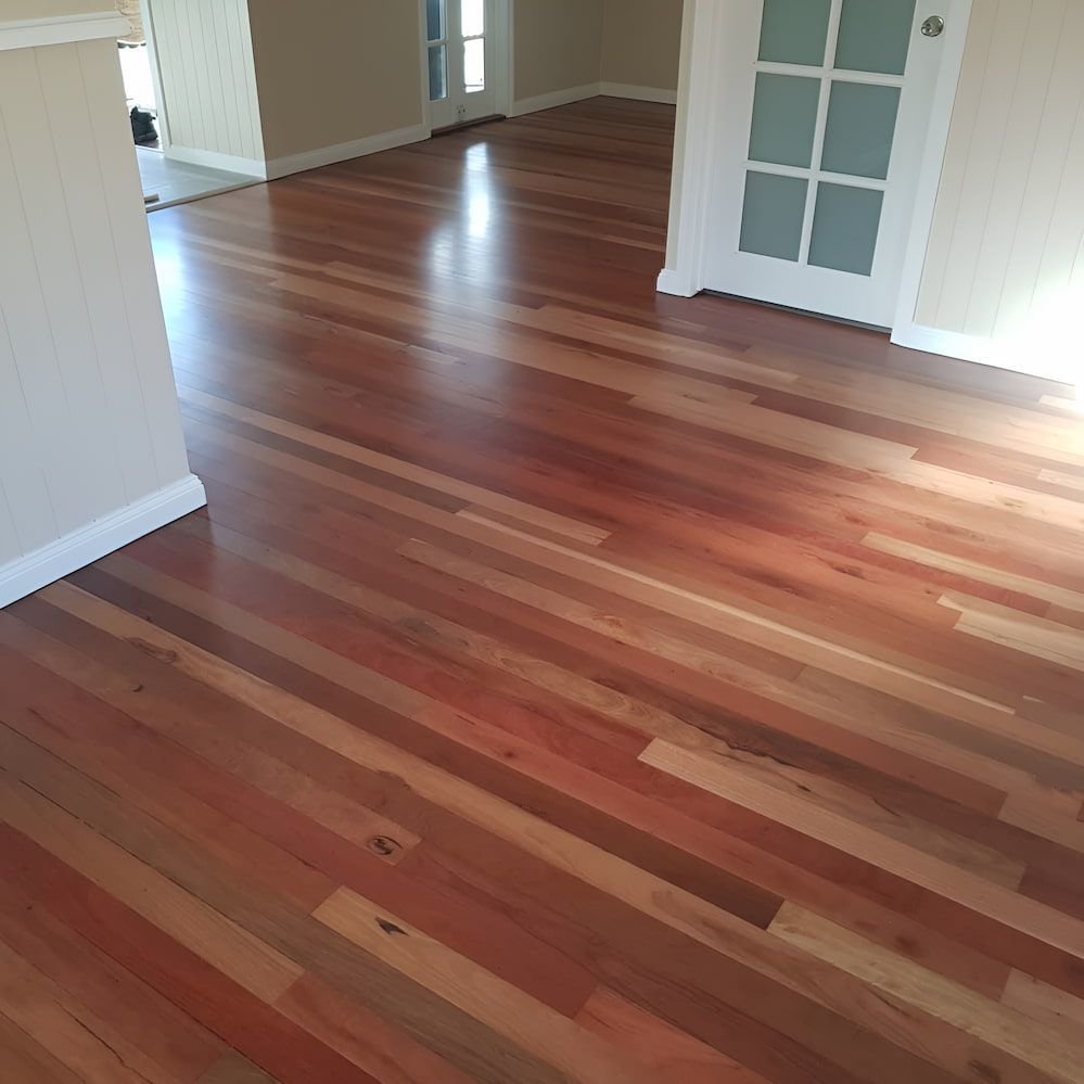 A Living Room With A Wooden Floor And A White Door — ATM Floors In Ingham, QLD