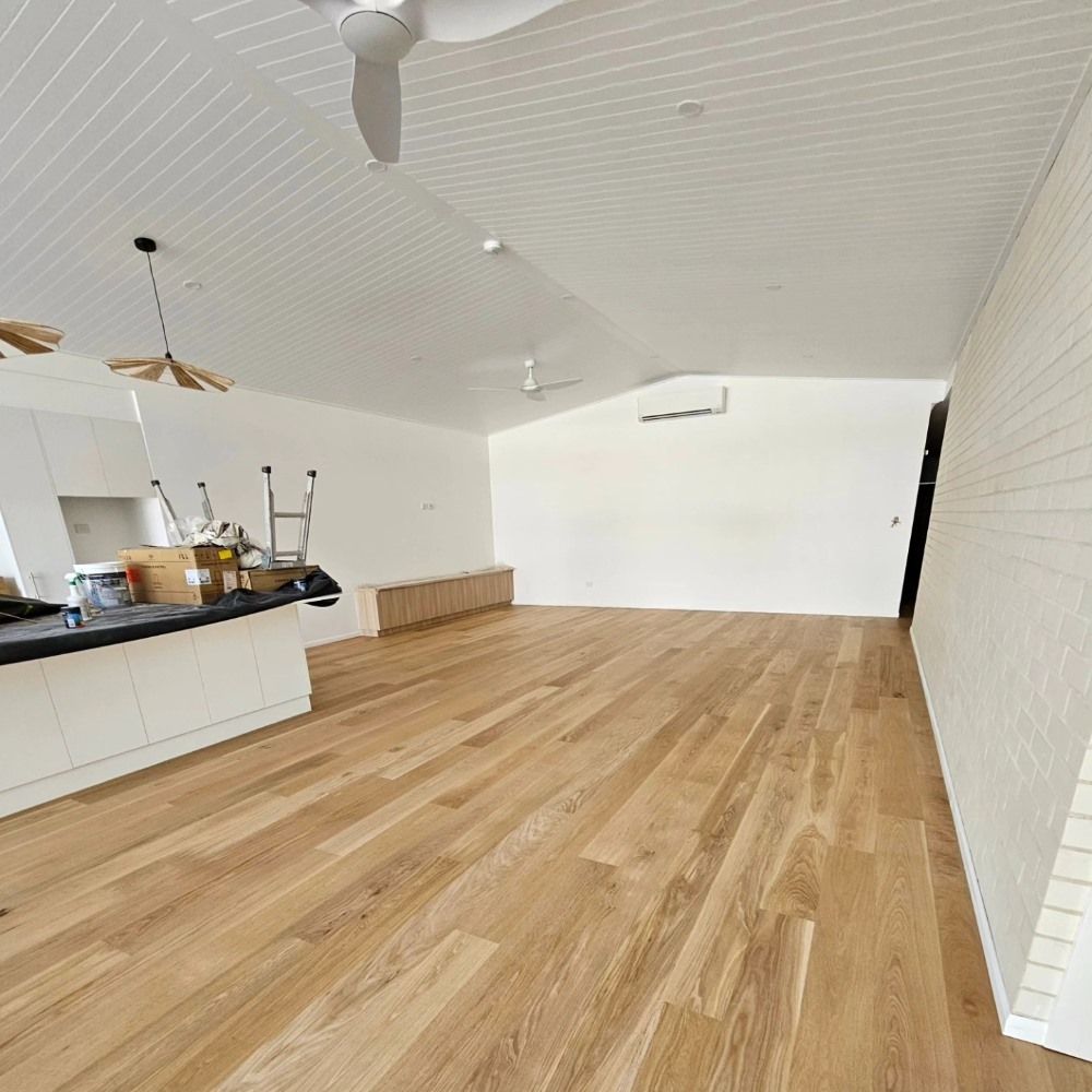 A Large Empty Room With Hardwood Floors and a Ceiling Fan — ATM Floors In Mount Louisa, QLD