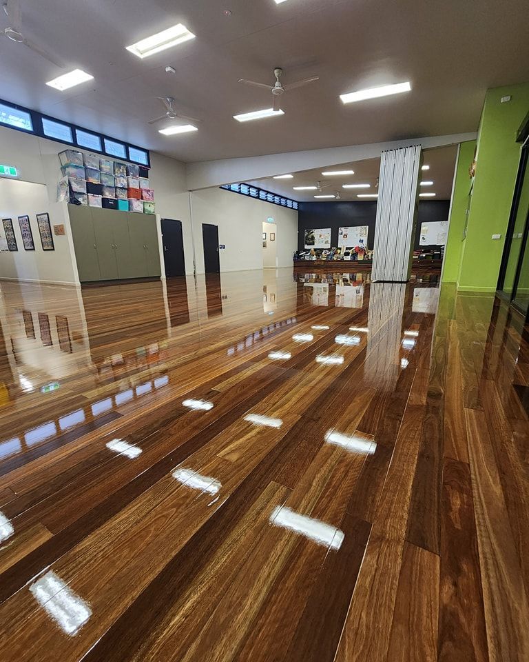 A Person is Laying Wooden Flooring in a Room — ATM Floors In Mount Louisa, QLD