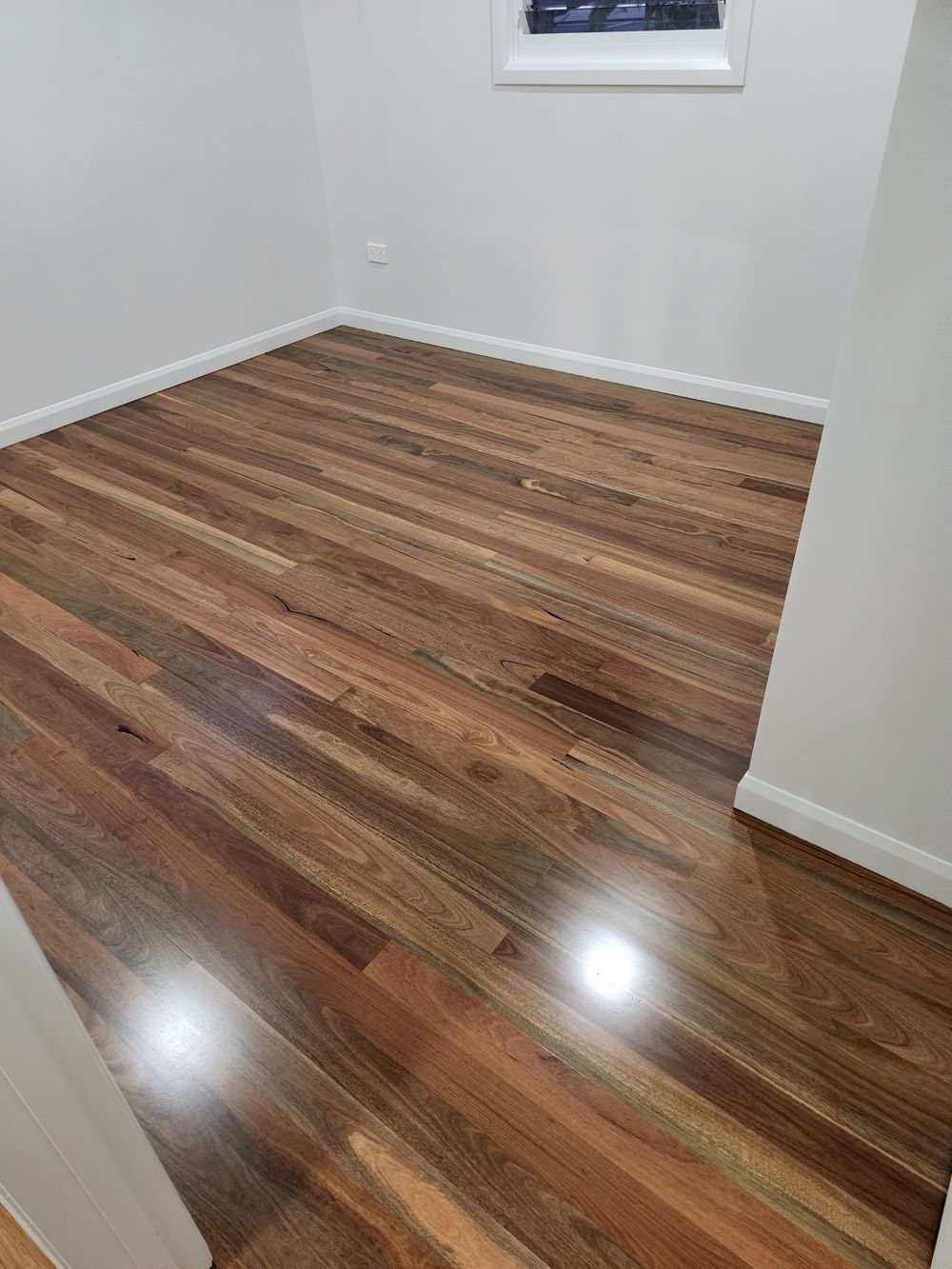 A Large Empty Room With Hardwood Floors and a Ceiling Fan — ATM Floors In Mount Louisa, QLD