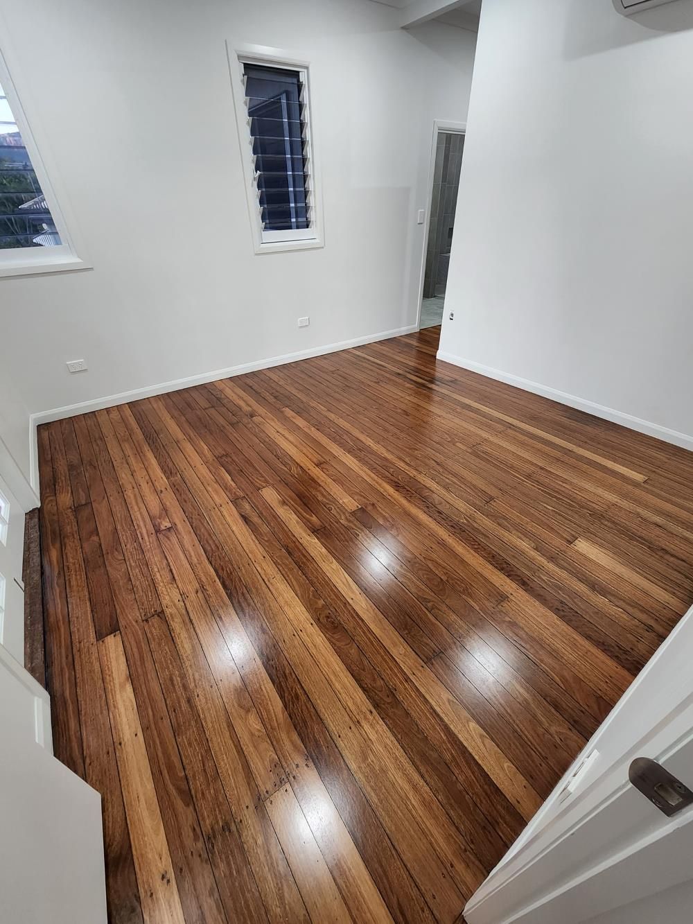 A Room With a Wooden Floor and White Walls — ATM Floors In Ayr, QLD
