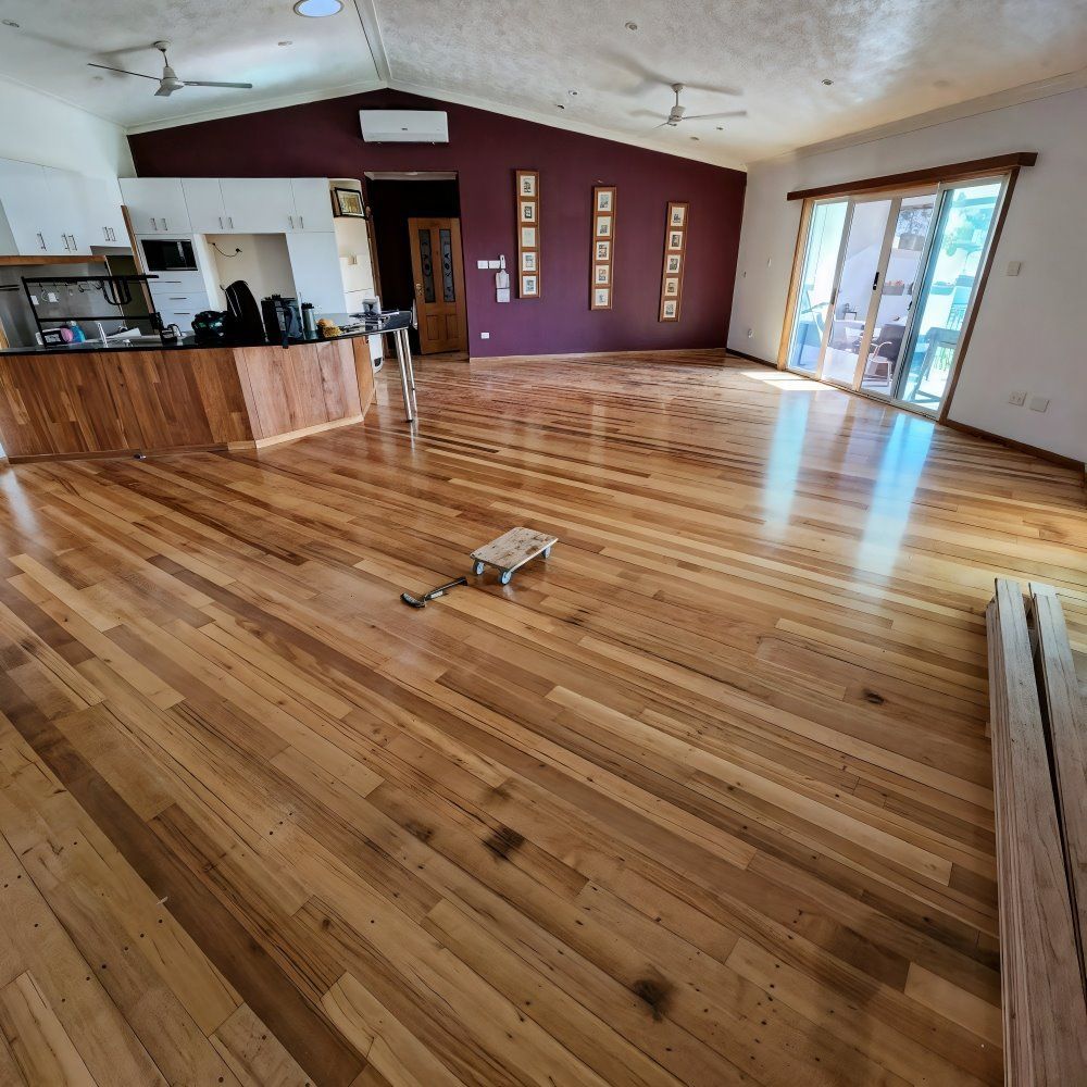 A Large Room With a Wooden Floor and a Purple Wall — ATM Floors In Mount Louisa, QLD
