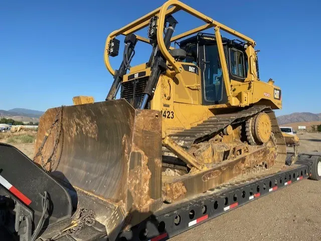 A small stone bridge over a creek with a truck parked nearby. The water is muddy.