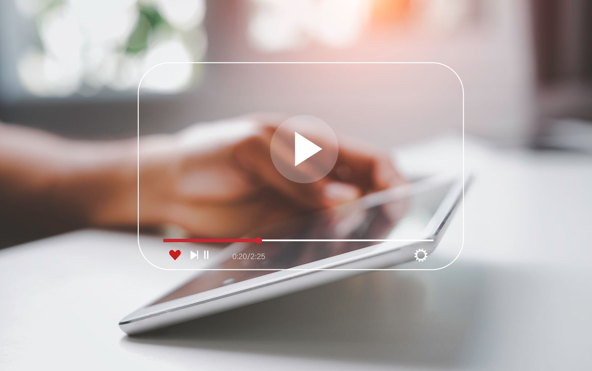 Person using a tablet, overlaid with a video player interface. A red progress bar indicates video playback.