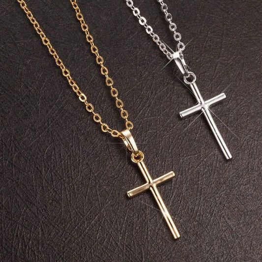 Two gold and silver cross necklaces on a dark textured surface.