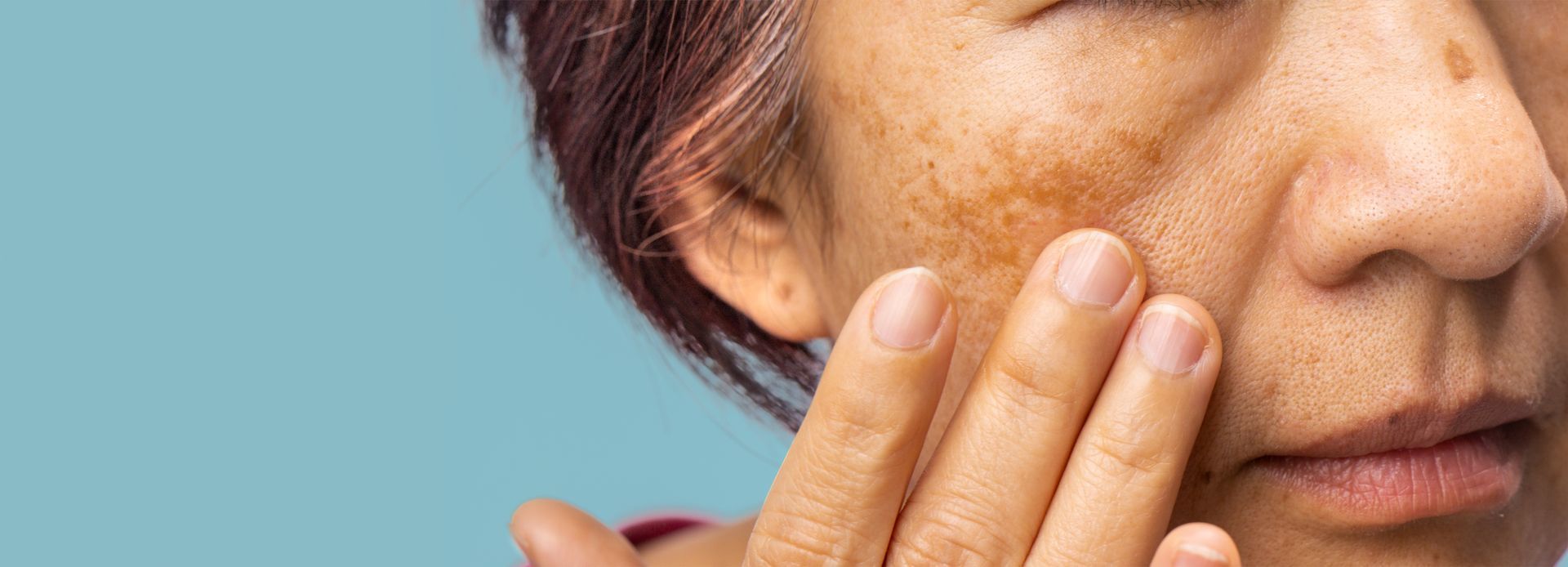 A close up of a woman 's face with a hand on it.