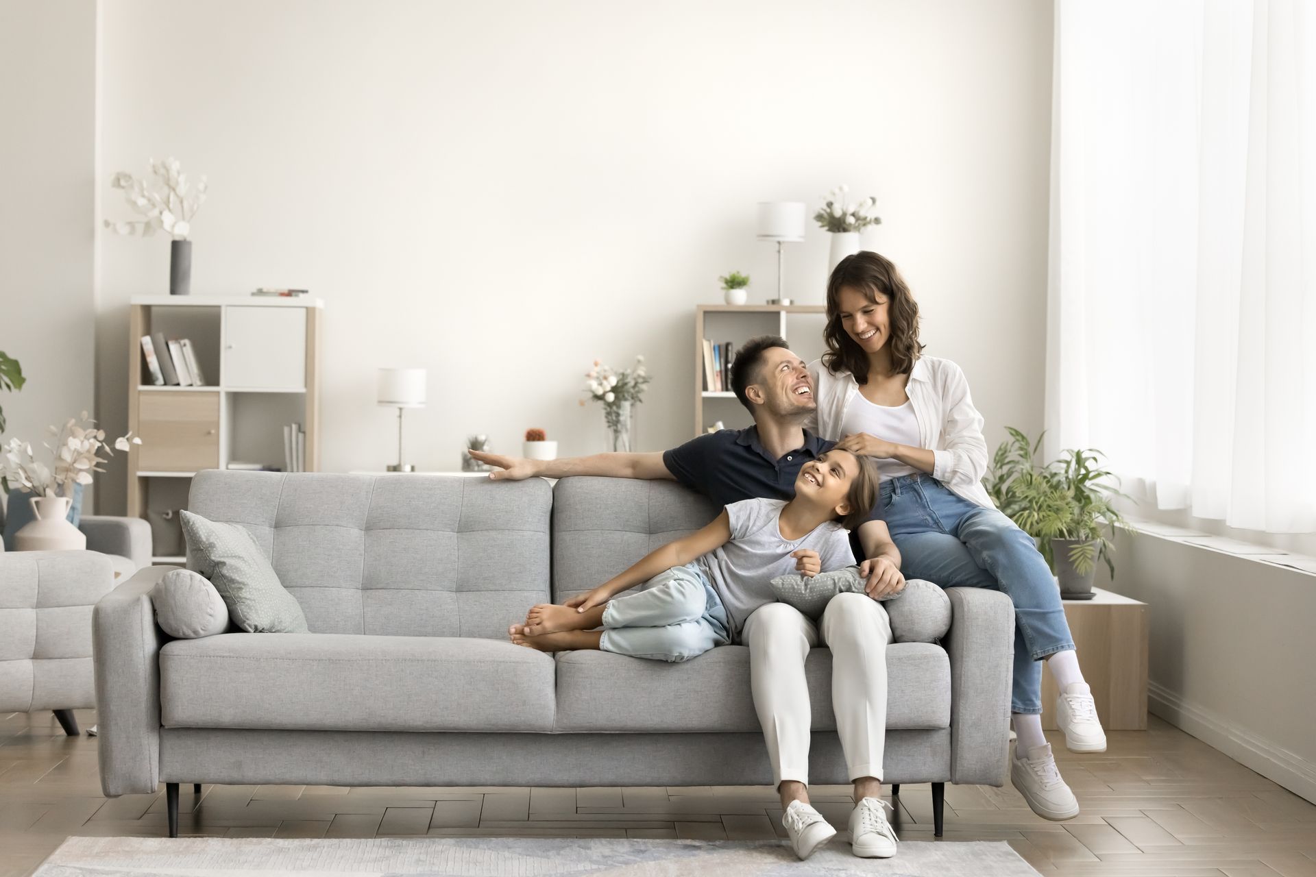 A family is sitting on a couch in a living room.