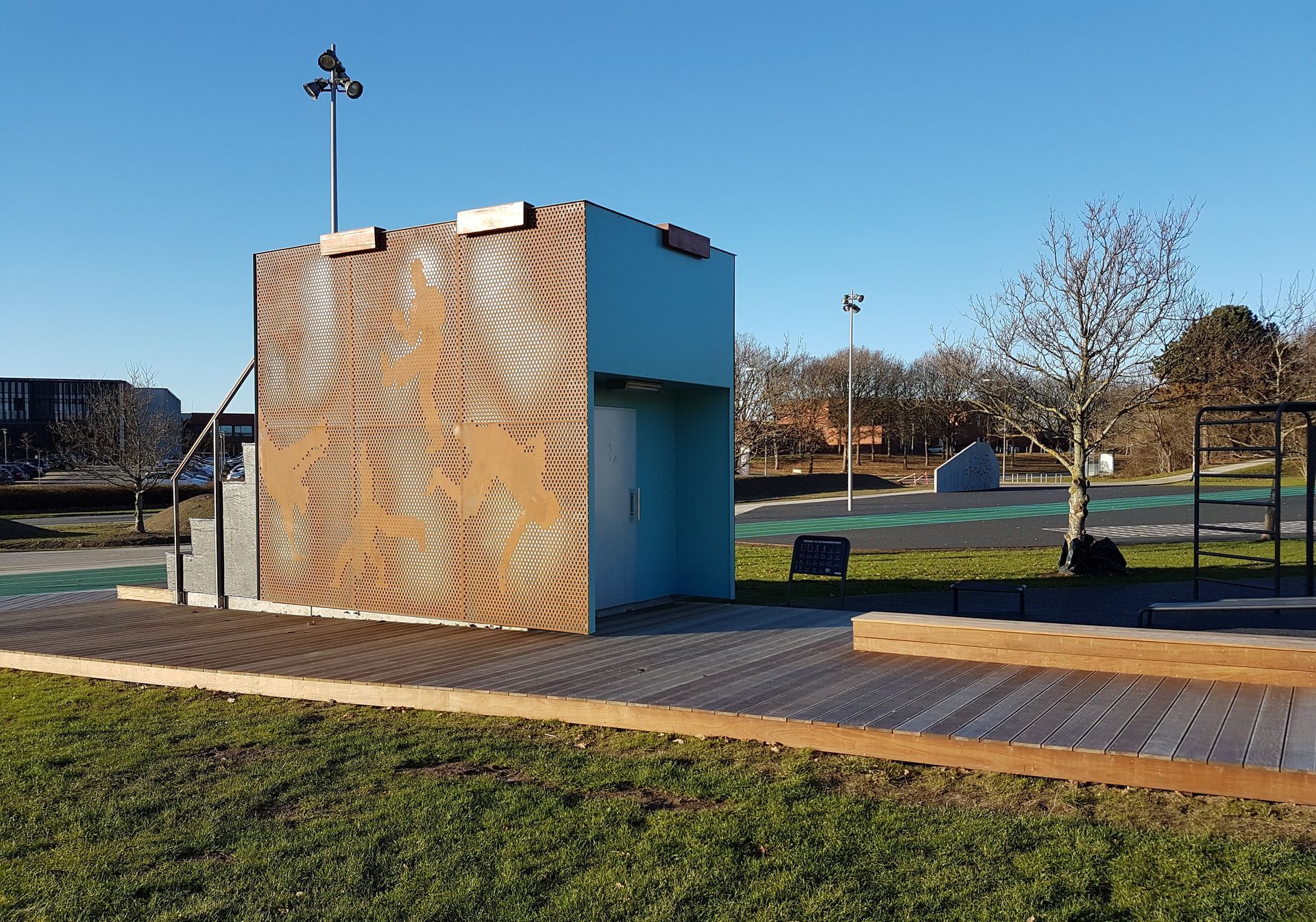 En lille bygning sidder midt på en græsmark.