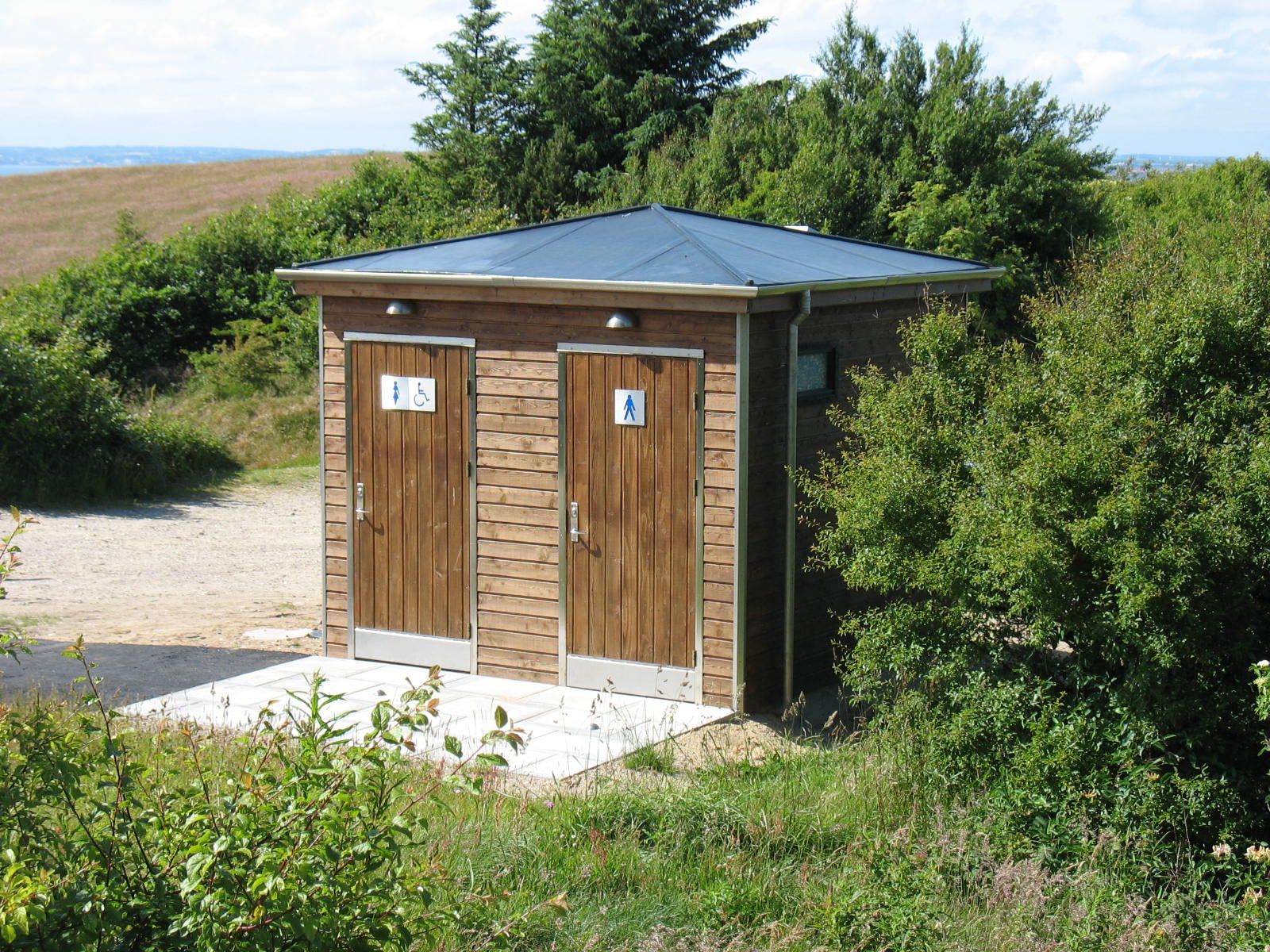 En lille træbygning med to toiletter i