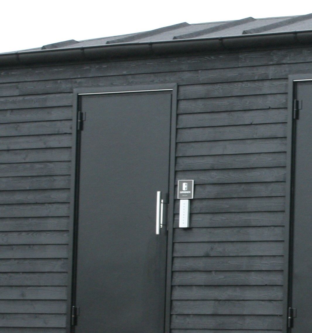 En sort bygning med en dør, der har bogstavet b på