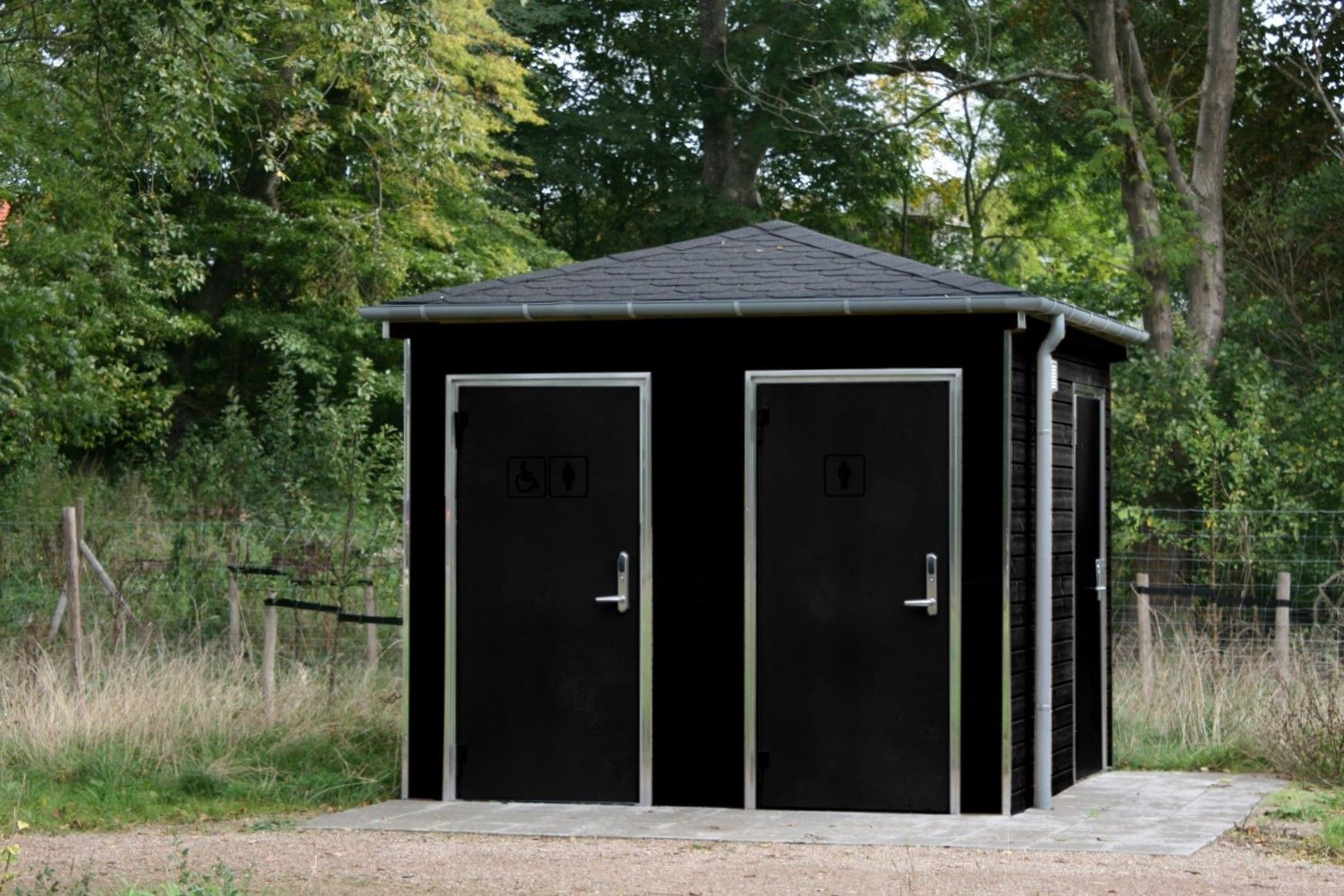 Et sort skur med to døre midt på en mark