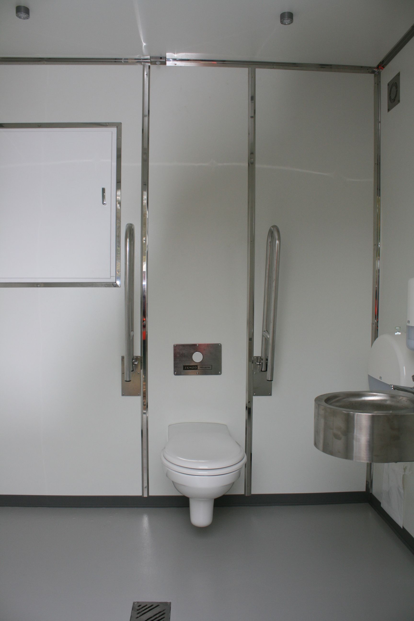 Et badeværelse med toilet og håndvask i