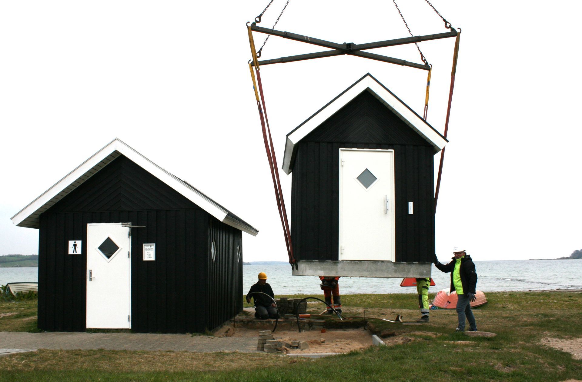 To små huse bliver løftet af en kran