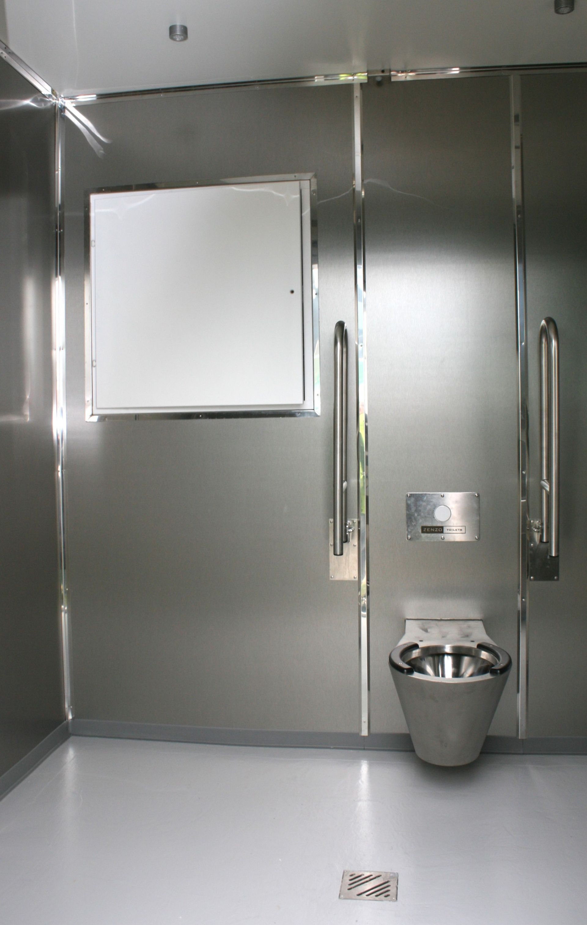 Et badeværelse med rustfri stålvægge og et toilet