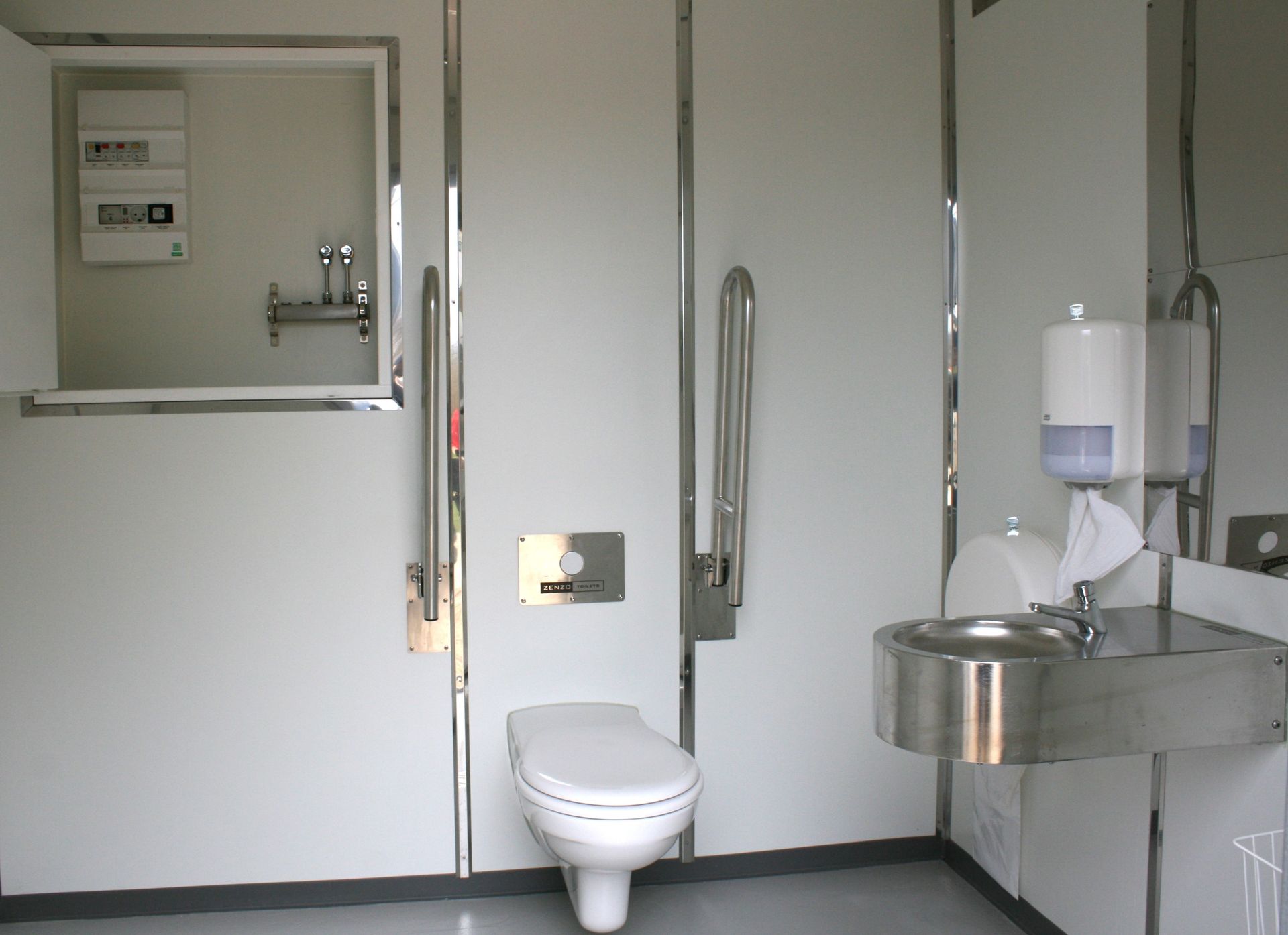 Et badeværelse med toilet, håndvask og spejl