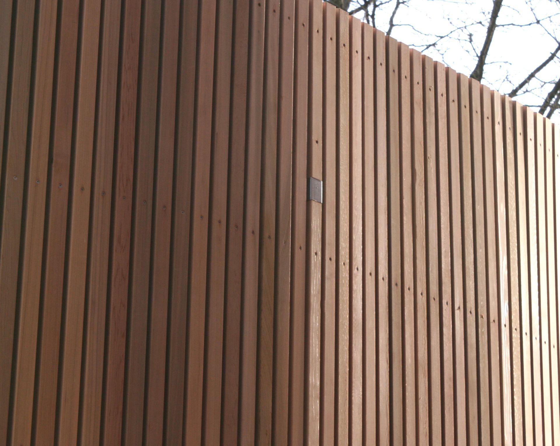 Et nærbillede af et plankeværk med træer i baggrunden.