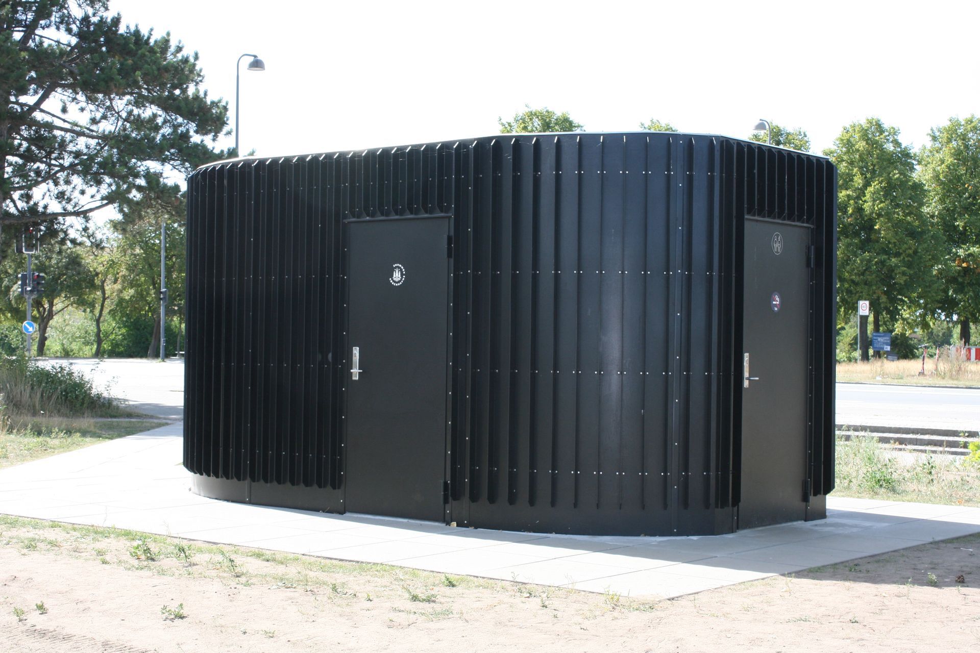 En sort bygning med to døre på siden af ​​den