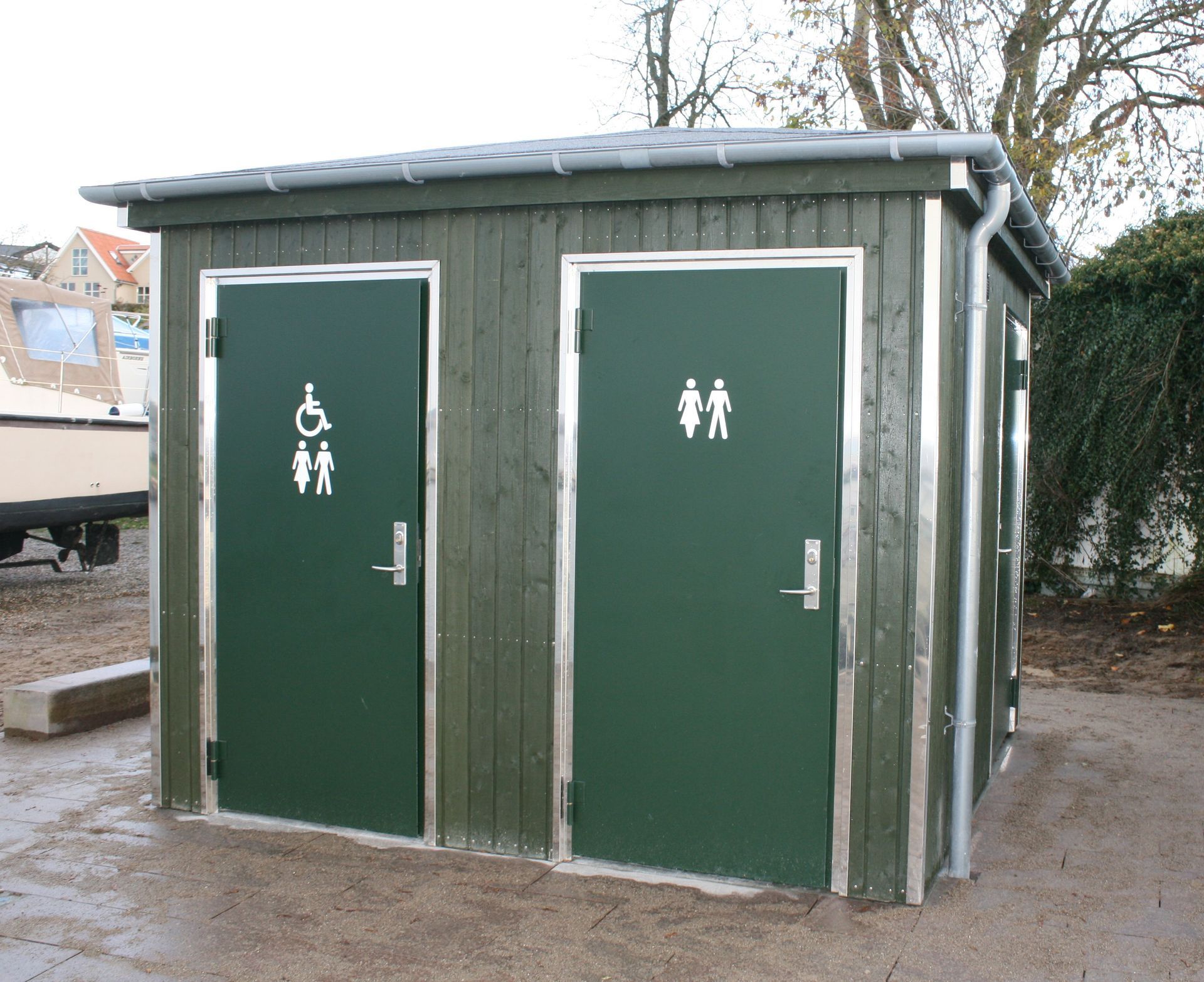 To grønne døre med et handicapskilt på den ene