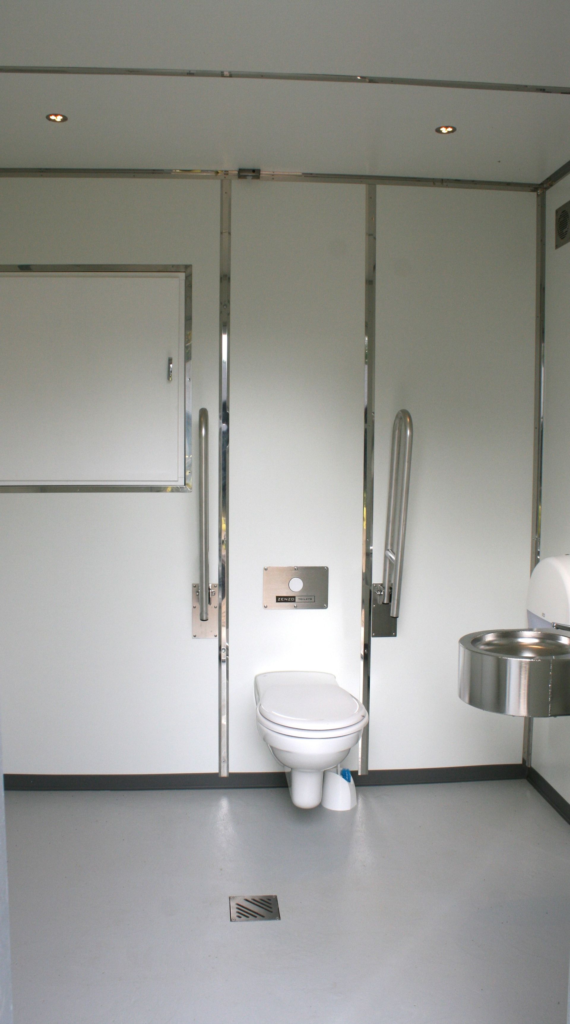 Et badeværelse med toilet og håndvask i