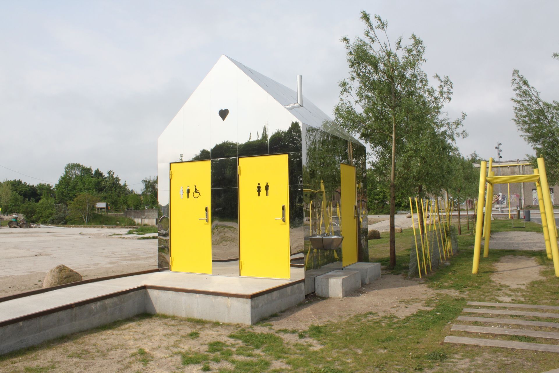 En hvid bygning med to gule døre foran