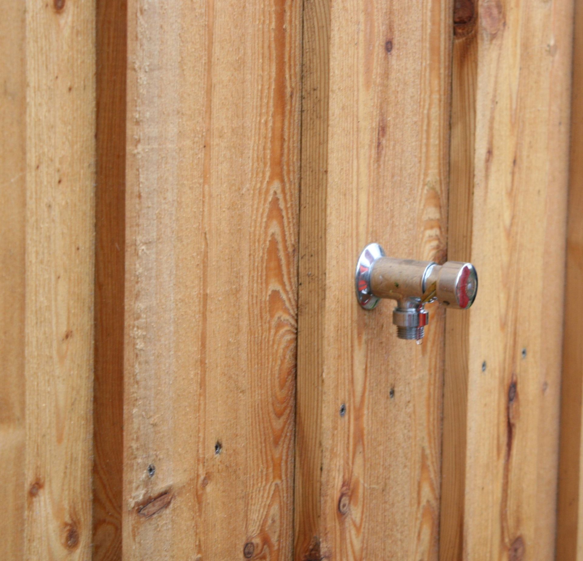 En vandhane er fastgjort til et plankeværk.